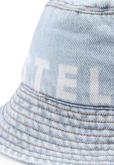 Cappello bucket in denim azzurro chiaro con cuciture visibili, tesa ampia e superficie testurizzata. Presenta un testo stampato audace in bianco sul pannello frontale.