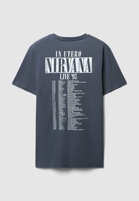 T-shirt in cotone blu navy con testo bianco: "IN UTERO NIRVANA LIVE '93" e un elenco di date e luoghi dei concerti sul retro.