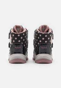 Černé vysoké tenisky s růžovými puntíky, suchými zipy a bílými akcenty. Mají lesklý povrch a detail s textem "Minnie".