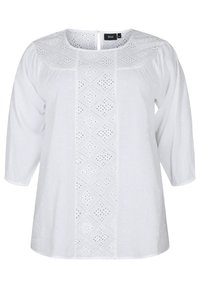 Hvid bluse med trekvartærmer, med broderie anglaise-detaljer i et diamantmønster, rund halsudskæring og knaplukning i ryggen.