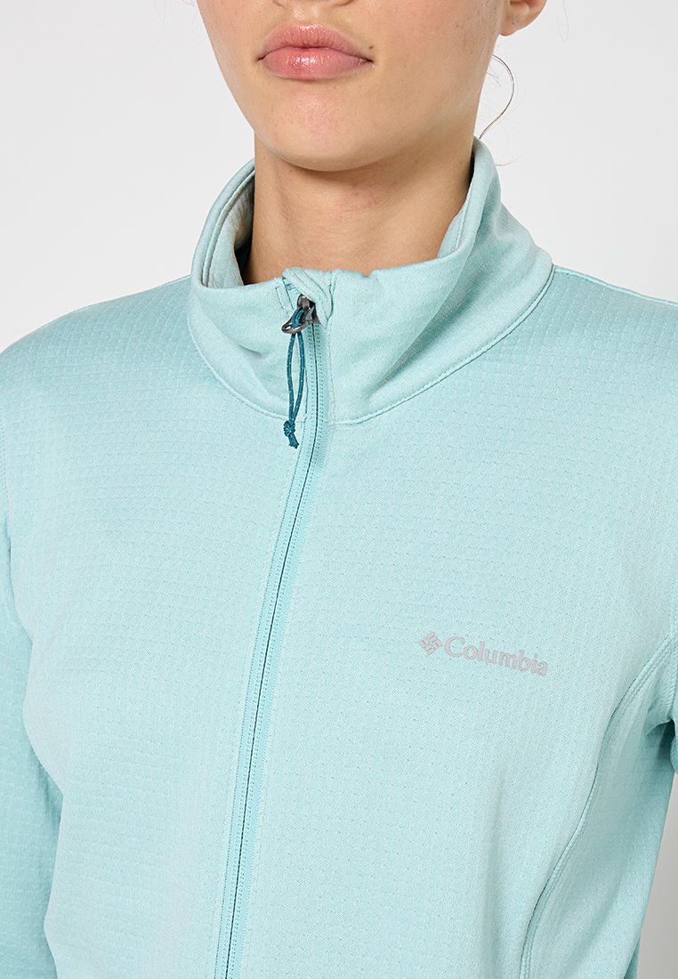 Hellblaues Zip-Jacke aus strukturiertem Stoff mit hohem Kragen und silbernem Logo auf der linken Brust. Verfügt über einen Kordelzug am Reißverschluss.