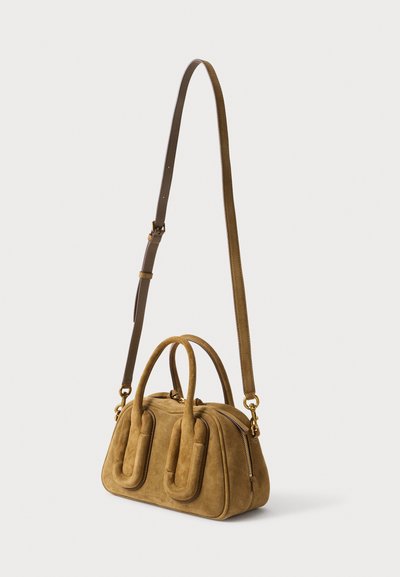 Sac à main en daim marron doux avec doubles poignées et longue bandoulière ajustable, doté de ferrures dorées et d'une fermeture éclair.