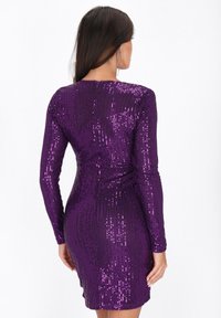 Rochie purpurie cu paiete, cu mâneci lungi, siluetă ajustată, suprafață texturată și închidere cu fermoar la spate.