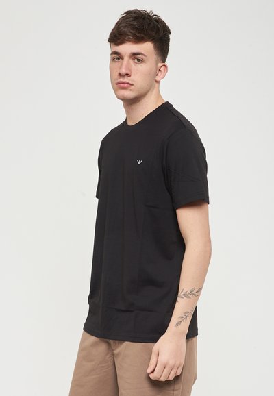 T-shirt noir à manches courtes avec un col rond, fabriqué en coton doux, avec un petit logo sur la poitrine et une coupe décontractée.
