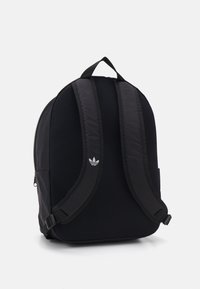Black backpack with mesh texture, padded straps, and side pocket. Features a small white Adidas logo on the front.