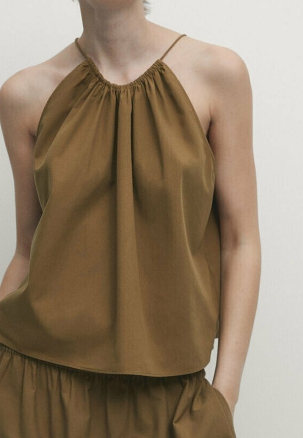 Haut à bretelles marron sans manches en tissu léger avec encolure froncée et coupe ample, associé à une jupe assortie.