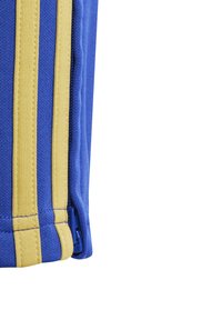 Blauwe stof met gele strepen, met een zichtbare rits aan de naad en een textuur die duurzaamheid en functionaliteit suggereert.