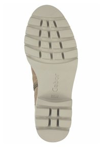 Semelle de chaussure marron clair avec un caoutchouc texturé pour l'adhérence, présentant un motif en zigzag et un logo en relief, se rétrécissant vers le bout.