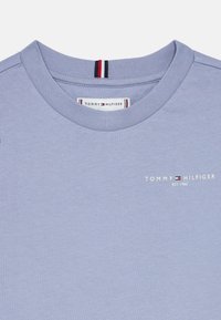 Ανοιχτό μπλε κοντομάνικο μπλουζάκι από βαμβάκι. Διαθέτει στρογγυλή λαιμόκοψη και ένα μικρό λευκό λογότυπο με κόκκινες και ναυτικές λεπτομέρειες στο στήθος.