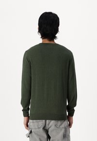 Pullover verde a maniche lunghe con polsini e orlo a coste, realizzato in un materiale morbido e con un classico design a girocollo.
