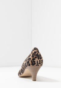 Leopardmönstrad högklackad sko i mocka; spetsig tå, texturerad ovansida och en 2 tum hög klack. Bakifrån visas design och silhuett.
