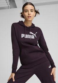 Felpa con cappuccio di colore viola scuro realizzata in tessuto morbido, con tasca frontale, polsini a costine e un grande logo bianco della Puma sul petto.