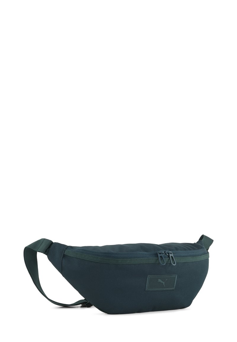 Marsupio verde scuro realizzato in tessuto resistente, dotato di un compartimento principale con zip, cintura regolabile e una patch logo testurizzata.