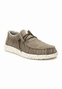 Zapato de tela marrón con textura, suela moteada blanca y detalles de cordones marrones, con un forro interior a rayas.