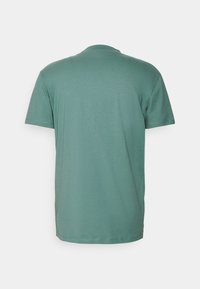 T-shirt à manches courtes en tissu vert doux. Présente un col rond classique et une texture lisse sans motifs ni ornements visibles.