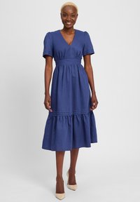 Navy blue dress with a V-neck and puffed short sleeves. Features a fitted waist and tiered skirt with horizontal stitching details.