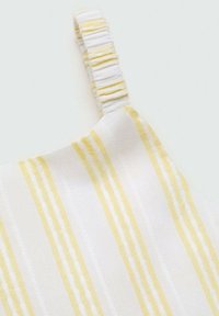 White fabric top with yellow vertical stripes, featuring a gathered strap design. Smooth texture with distinct color contrast.