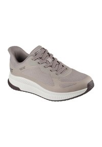 Zapato deportivo gris claro con parte superior de malla transpirable, detalles texturizados y una entresuela blanca. Cuenta con cordones y una suela exterior de goma resistente.
