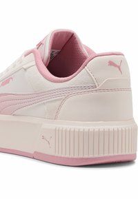 Sneakers Puma in rosa chiaro e crema, con sezioni in pelle liscia e camoscio, forma arrotondata e una suola testurizzata con accentuazioni a righe.