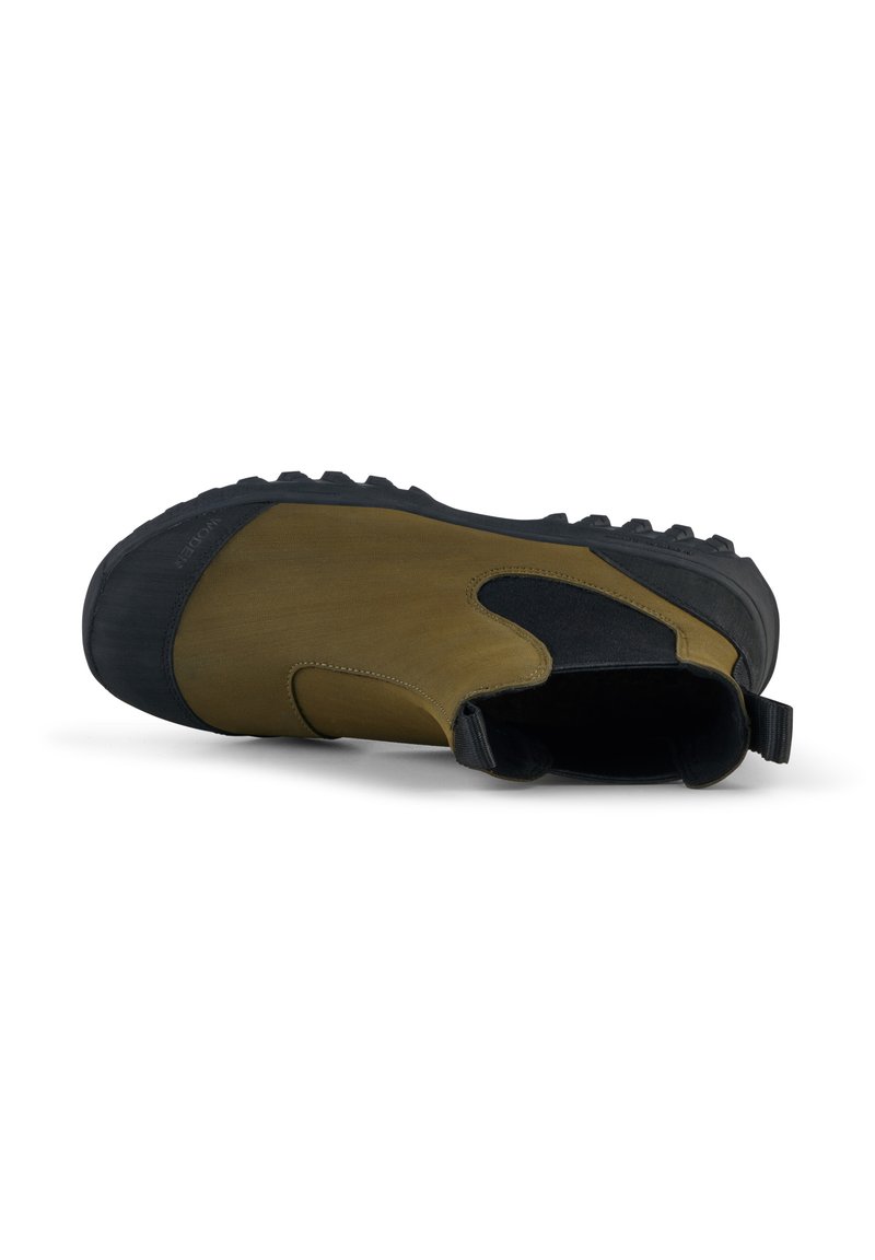 Zapato marrón y negro con suela de goma, parte superior de textil, panel lateral elástico y una tira trasera para facilitar su colocación. Cuenta con un agarre texturizado.