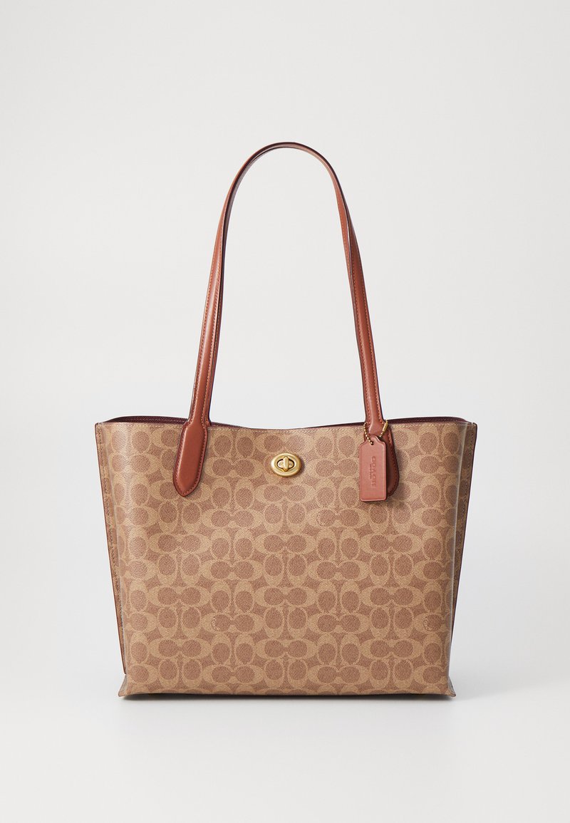 Brown tote bag with a signature pattern, leather handles, gold-tone hardware, and a small tag. Soft texture, spacious interior.