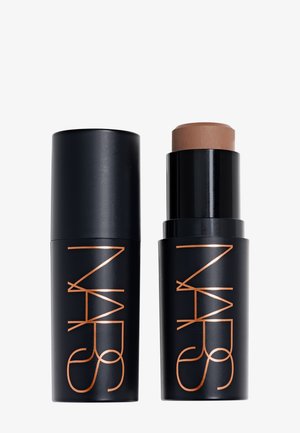 Svart NARS sminkestift med avtakbart lokk som viser middels brunt produkt inni, med logo trykt i kobber på begge deler.