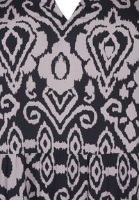 Svart och grå klänning med V-ringning och intrikata blommönster och geometriska mönster, med en draperad kjoldetalj. Mjuk tygtextur.