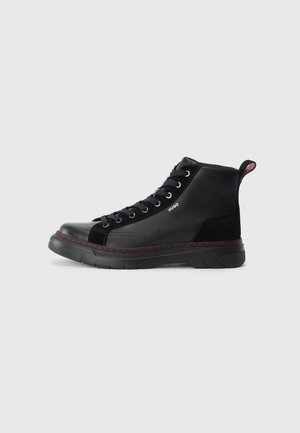Mustad mustad kõrged sneakers, mis on valmistatud nahast ja sametist, millel on lamedad paelad, punane aktsentõmblus ja struktuurne talla muster, mis tagab haarde.