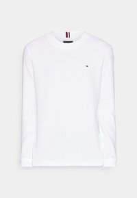Vit långärmad sweatshirt i bomull med ribbad mudd och nederkant. Har en liten logotyp på bröstet och en randig detalj vid halsringningen.