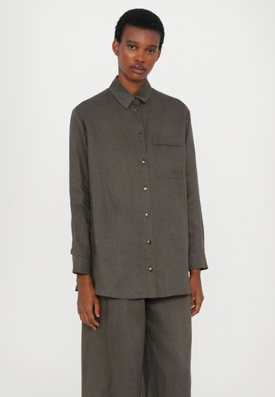 Γκρι πο�υκάμισο με κουμπιά και μακριά μανίκια, τσέπη στο στήθος και ελαφρώς υφασμάτινη υφή. Διαθέτει μεταλλικά κουμπιά και άνετη εφαρμογή.