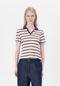 Kurze Ärmel, gestricktes Poloshirt in Creme mit burgunderfarbenen horizontalen Streifen, mit V-Ausschnitt und kontrastierendem Kragen. Getragen mit dunklen Hosen.