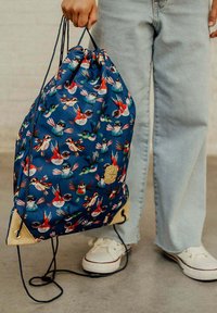Trekzak met treksluiting van blauwe stof met kleurrijke vogelpatronen, beige accenten aan de onderkant en verstelbare schouderbanden.