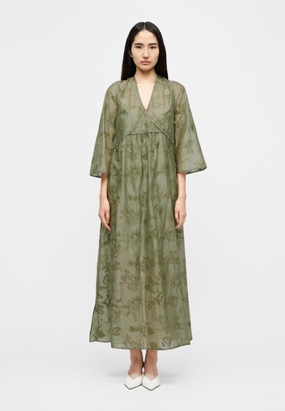 Φόρεμα μάξι σε ελαιί πράσινο χρώμα, διαφανές, με βοτανική κεντητική, V λαιμόκοψη και φαρδιά μανίκια. Διαθέτει λεπτή δαντέλα στη μέση.