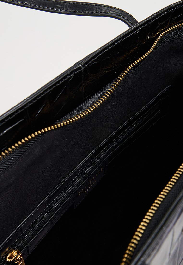 Black leather handbag with a crocodile texture, gold zipper detailing, and a black fabric interior featuring an additional zip pocket.