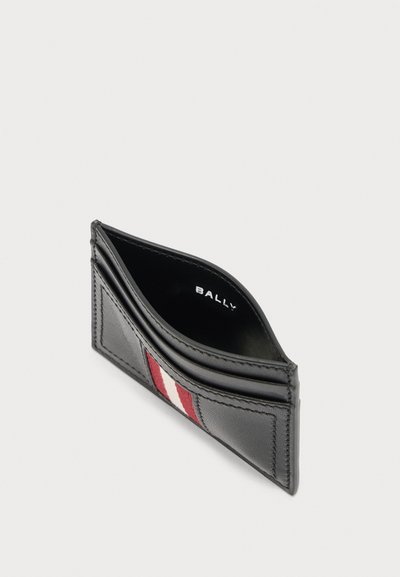 Porte-cartes en cuir noir avec détail rayé rouge et blanc, plusieurs emplacements pour cartes, et logo "BALLY" à l'intérieur.