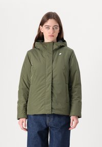 Giacca isolante verde oliva con cappuccio, chiusura con zip, due tasche laterali e un piccolo logo sul petto. Tessuto testurizzato e resistente all'acqua.