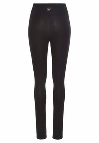 Black leggings with a high waistband, smooth texture, and a small brand logo tag at the back. Design emphasizes a fitted silhouette.