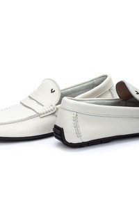 Mocasines de cuero blanco con una banda cosida en la parte frontal, forma redondeada y suela de goma negra. Forro interior suave visible.