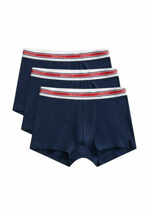 Drei marineblaue Herren-Boxershorts mit weißen Taillenbündchen, die einen roten Streifen und den Markennamen "GANT" in Weiß wiederholt zeigen.