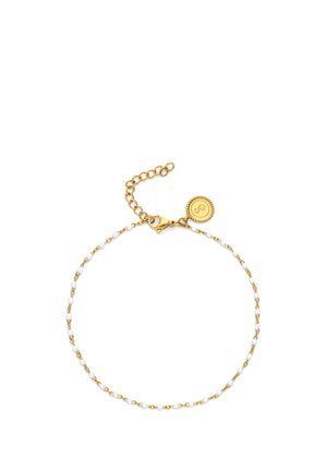 Delicada pulsera de cadena dorada con pequeñas cuentas blancas, cierre de langosta, eslabones ajustables y un charm redondo dorado con diseño en relieve.