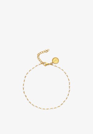 Delicada pulsera de cadena dorada con pequeñas cuentas blancas, cierre de langosta, eslabones ajustables y un charm redondo dorado con diseño en relieve.