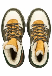 Scarpe da trekking realizzate in una combinazione di pelle bianca, camoscio marrone e dettagli gialli, con lacci grigi e una fodera morbida e pelosa.