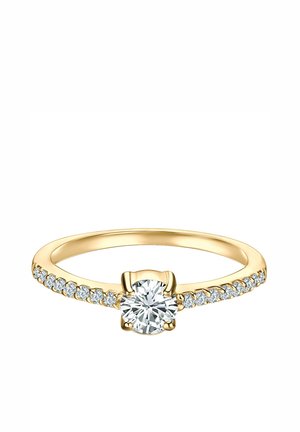Anillo de oro con un gran diamante redondo central y diamantes más pequeños colocados a lo largo de la banda en ambos lados.