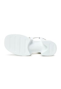 Sandal bianca con suola liscia, caratterizzata da un design con strappi. La parte inferiore ha una superficie texturizzata con scanalature orizzontali per una migliore aderenza.