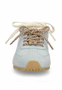 Lichtblauwe suède sneaker met beige rubberen zool en tweekleurige bruin-witte veters in een strik, gezien van voren.