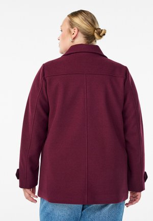 Burgundy wool blend coat with a notched collar and side pockets. Features a relaxed fit and button details on the sleeves.