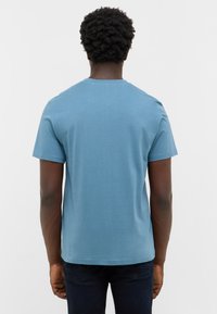 Niebieska bawełniana koszulka z okrągłym dekoltem i krótkimi rękawami, zaprezentowana z tyłu, ukazująca gładką strukturę i dopasowany krój.