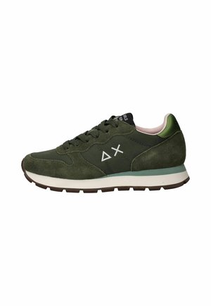 Groene suède en stoffen sneaker met witte zool, zwarte veters en witte driehoek- en X-symbolen aan de zijkant.
