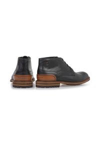 Stivali ankle in pelle nera con una finitura liscia, accento marrone nel tacco e suola in gomma resistente con un motivo di battistrada.