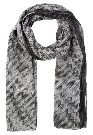 Écharpe légère avec motif zigzag noir et blanc et bords noirs transparents, bouclée lâchement en haut.